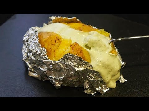 Asado de patatas al horno en papel de aluminio en la parrilla de carbón